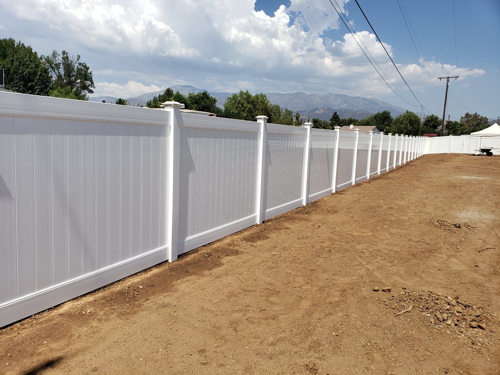 Long white vinyl privacy fence with mountain views built in Yucaipa, CA